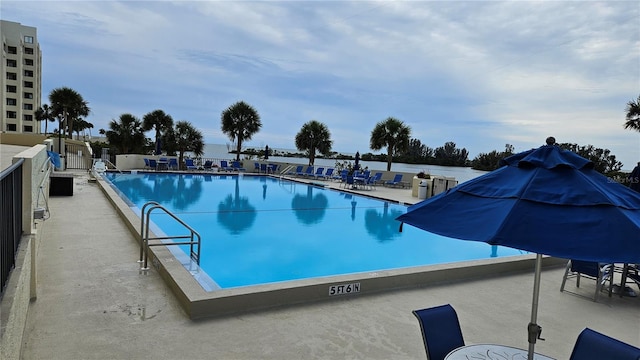 community pool featuring fence and a patio