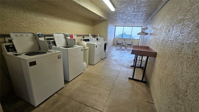 community laundry room featuring a textured wall and independent washer and dryer
