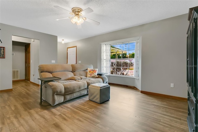 432 Taylorville St, Deltona, FL 32725 - living area featuring a textured ceiling, light wood-type flooring, baseboards, visible vents, and ceiling fan