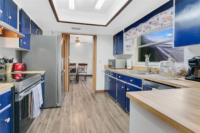 432 Taylorville St, Deltona, FL 32725 - kitchen featuring stainless steel appliances, a tray ceiling, a sink, and blue cabinetry