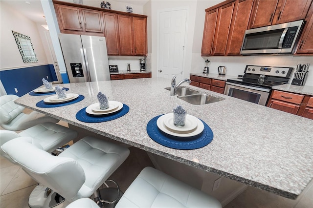 1781 Sawyer Palm Pl, Kissimmee, FL 34747 - kitchen featuring stainless steel appliances, a kitchen island with sink, a sink, backsplash, and a kitchen bar