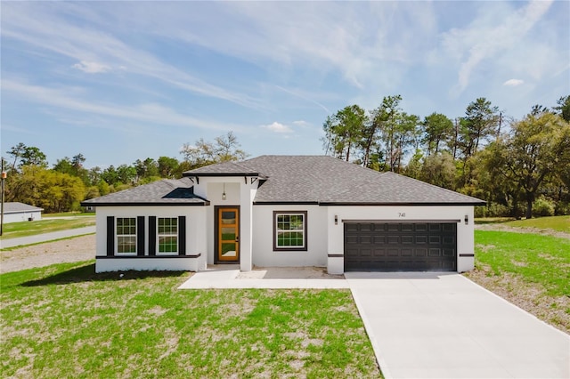 view of front of house with a front lawn, driveway, an attached garage, stucco siding, and roof with shingles