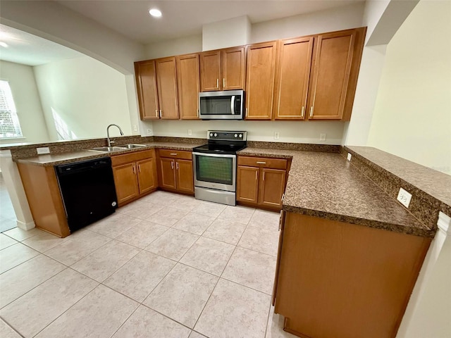 8271 Maritime Flag St Unit 125, Windermere, FL 34786 - kitchen featuring brown cabinetry, a peninsula, appliances with stainless steel finishes, and a sink
