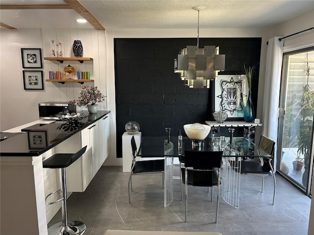 dining space featuring a textured ceiling and marble finish floor