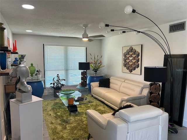 living area featuring a ceiling fan, a textured ceiling, visible vents, concrete flooring, and recessed lighting