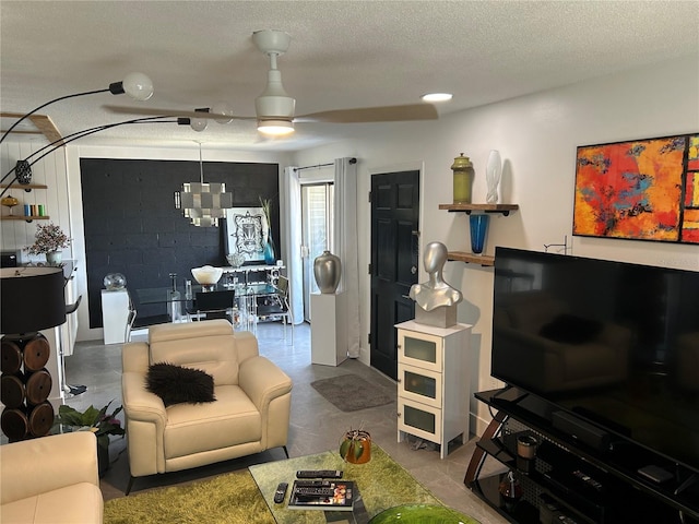 living area with a ceiling fan and a textured ceiling