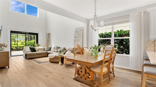 dining area featuring light wood-style flooring, a notable chandelier, and a healthy amount of sunlight