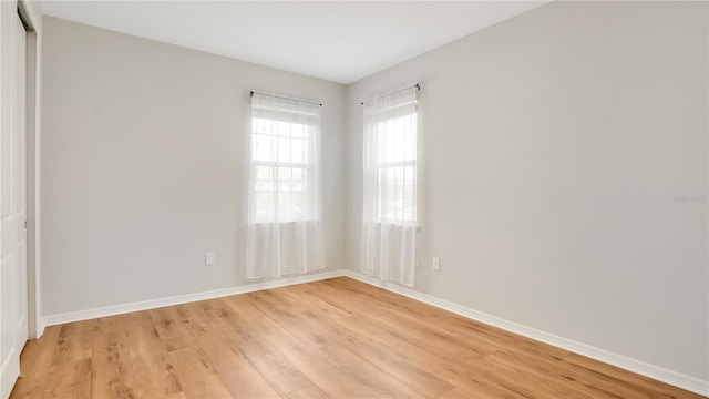 empty room with baseboards and light wood finished floors