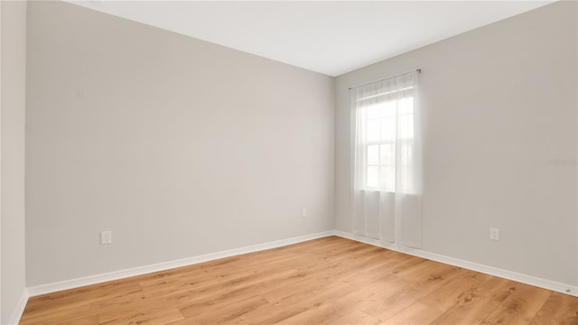 unfurnished room featuring baseboards and light wood-type flooring