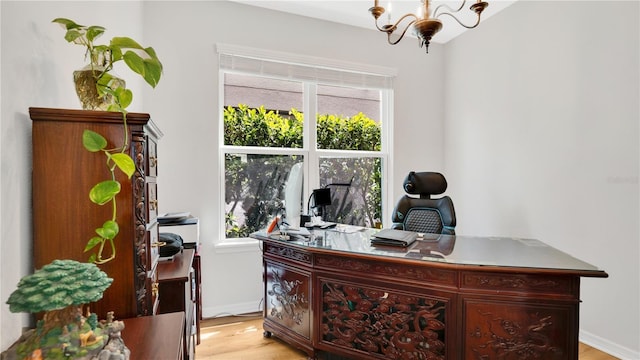 office area with an inviting chandelier, baseboards, and light wood-type flooring