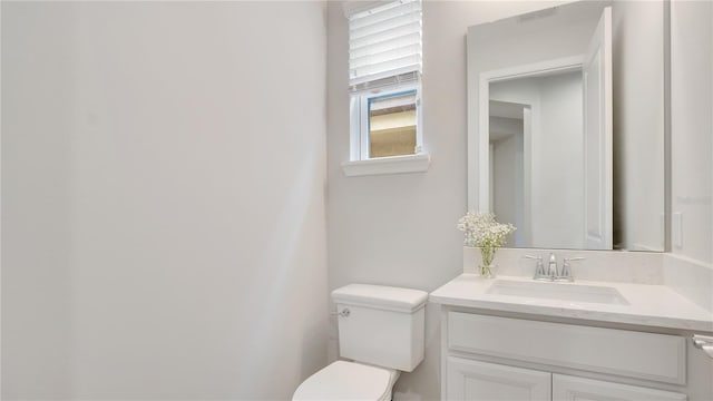 bathroom featuring vanity, toilet, and visible vents