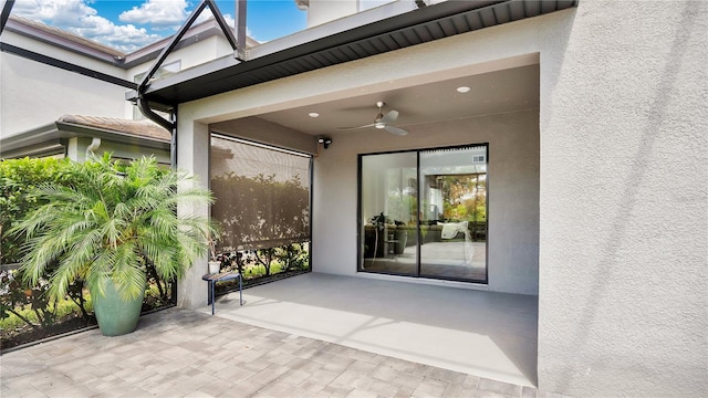 doorway to property featuring a patio, ceiling fan, and stucco siding