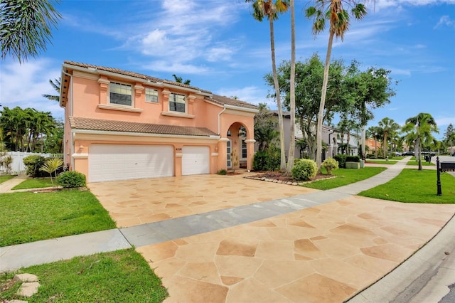 view of front of house with an attached garage, a tiled roof, a front yard, and stucco siding