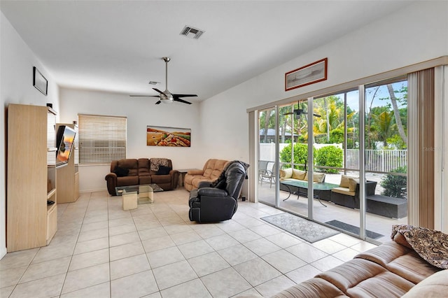 living room featuring light tile patterned floors, ceiling fan, vaulted ceiling, and visible vents