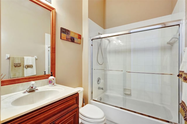 bathroom with toilet, vanity, and combined bath / shower with glass door
