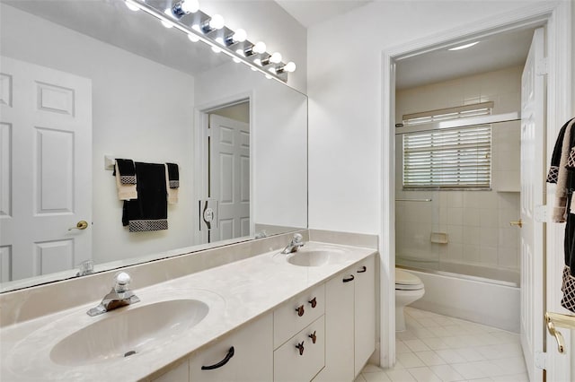 bathroom with toilet, tile patterned floors, double vanity, and a sink