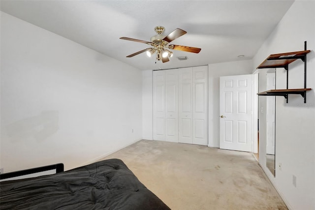 bedroom featuring a closet, baseboards, visible vents, ceiling fan, and light colored carpet