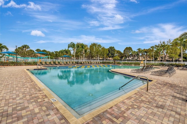 pool with fence and a patio