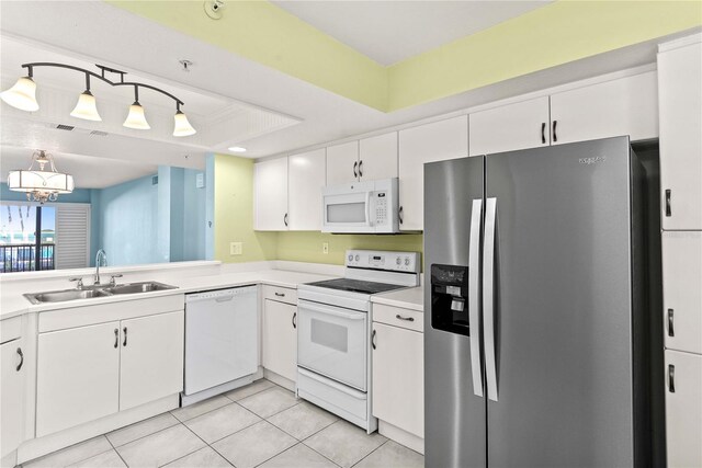 2700 N Peninsula Ave Unit 215, New Smyrna Beach, FL 32169 - kitchen featuring light countertops, light tile patterned floors, a sink, white appliances, and white cabinetry