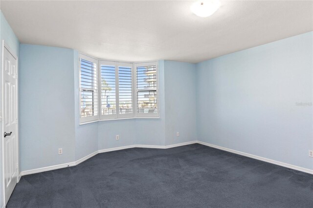 2700 N Peninsula Ave Unit 215, New Smyrna Beach, FL 32169 - unfurnished room featuring dark colored carpet and baseboards