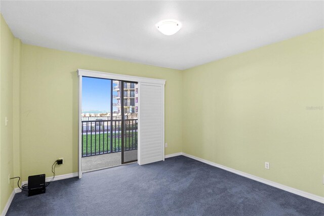 2700 N Peninsula Ave Unit 215, New Smyrna Beach, FL 32169 - unfurnished room with dark carpet and baseboards