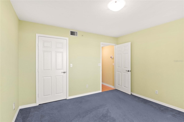 2700 N Peninsula Ave Unit 215, New Smyrna Beach, FL 32169 - unfurnished bedroom with baseboards, visible vents, and carpet floors