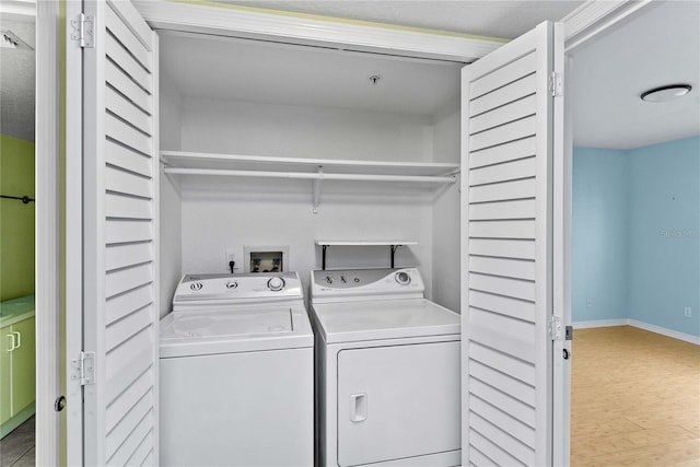2700 N Peninsula Ave Unit 215, New Smyrna Beach, FL 32169 - clothes washing area featuring baseboards, washer and clothes dryer, and laundry area