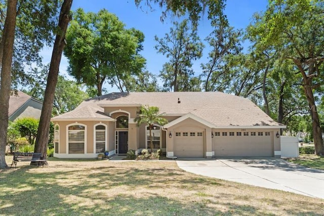 2082 Nexus Ct, Apopka, FL 32712 - view of front of home featuring an attached garage, stucco siding, concrete driveway, and a front yard
