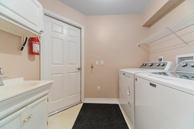 2082 Nexus Ct, Apopka, FL 32712 - clothes washing area featuring washing machine and clothes dryer, cabinet space, and a textured ceiling