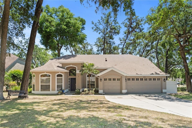 2082 Nexus Ct, Apopka, FL 32712 - mediterranean / spanish-style home with a garage, concrete driveway, stucco siding, a front yard, and a shingled roof