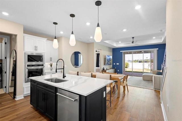 10215 Park Estates Ave, Orlando, FL 32836 - kitchen with appliances with stainless steel finishes, open floor plan, dark cabinetry, and a sink