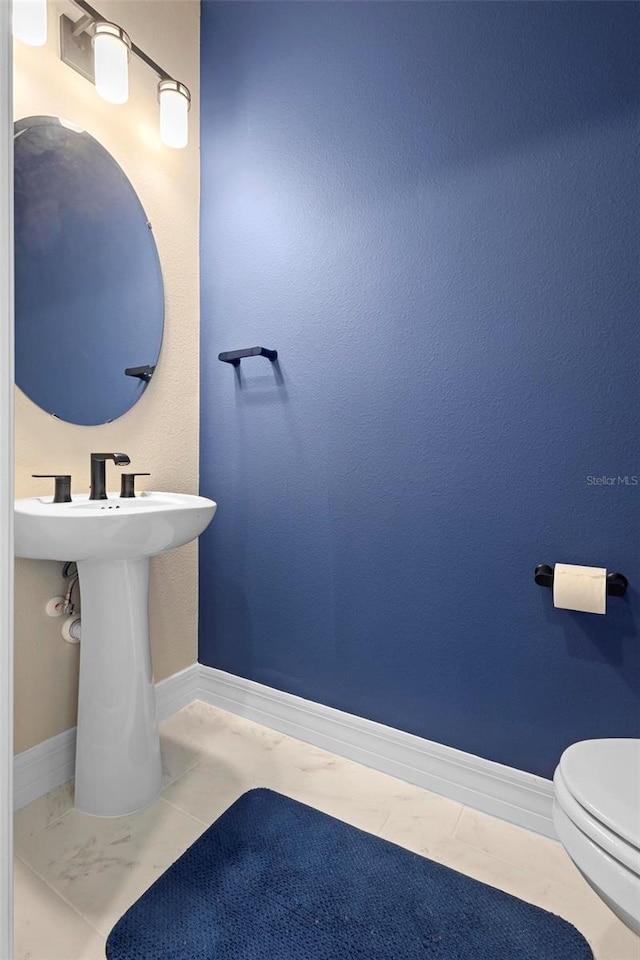 10215 Park Estates Ave, Orlando, FL 32836 - bathroom featuring toilet, baseboards, and a sink