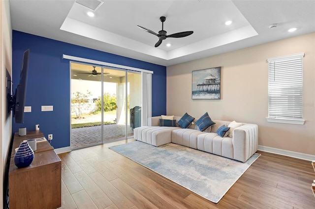 10215 Park Estates Ave, Orlando, FL 32836 - living room featuring a tray ceiling, a ceiling fan, and baseboards