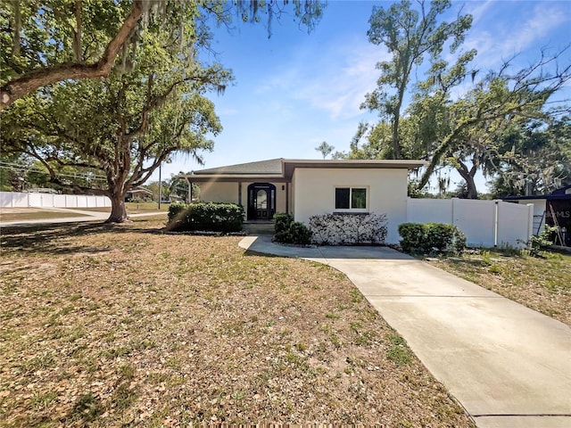 view of front of property featuring stucco siding and fence
