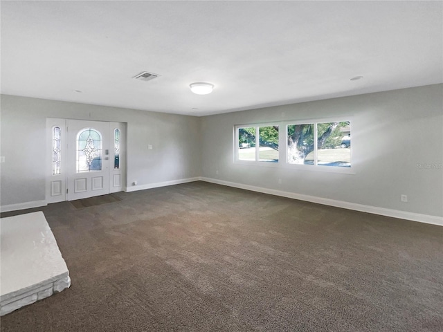 entryway with dark carpet, visible vents, and baseboards