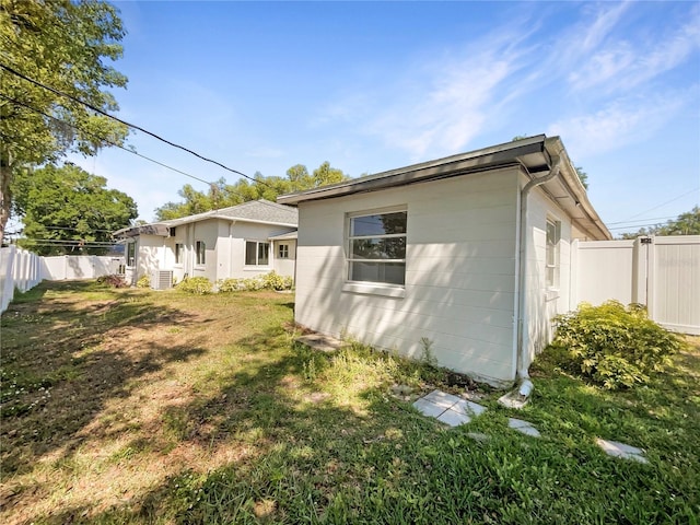 back of property featuring a fenced backyard and a lawn