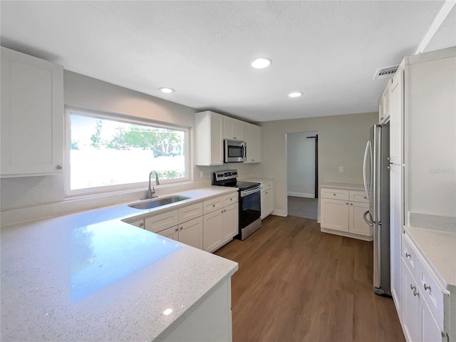 kitchen featuring light countertops, a sink, white cabinets, and stainless steel appliances