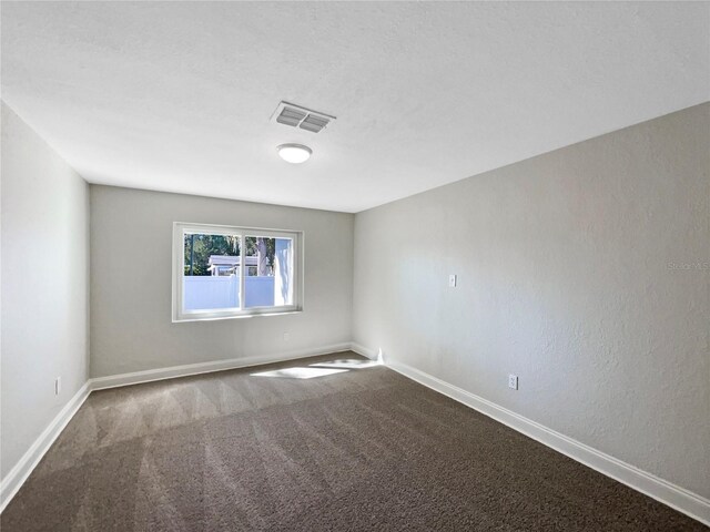 empty room featuring visible vents, baseboards, and carpet floors
