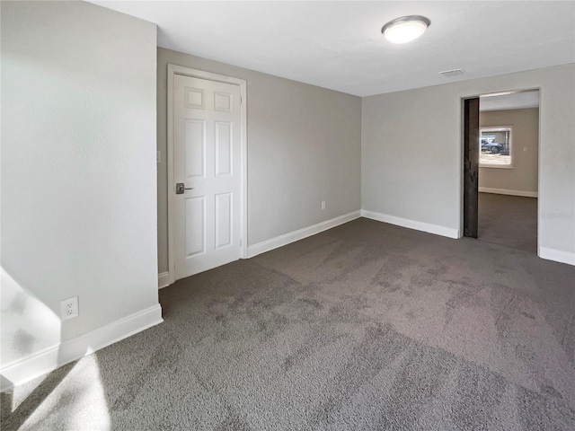 carpeted empty room with visible vents and baseboards