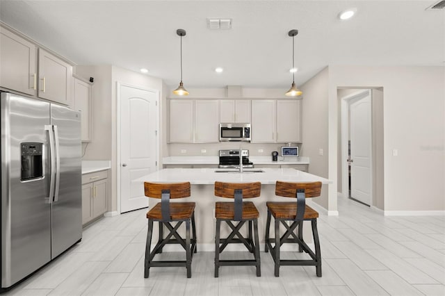 236 Pink Ibis Bnd, Saint Cloud, FL 34772 - kitchen featuring stainless steel appliances, light countertops, a kitchen bar, baseboards, and visible vents