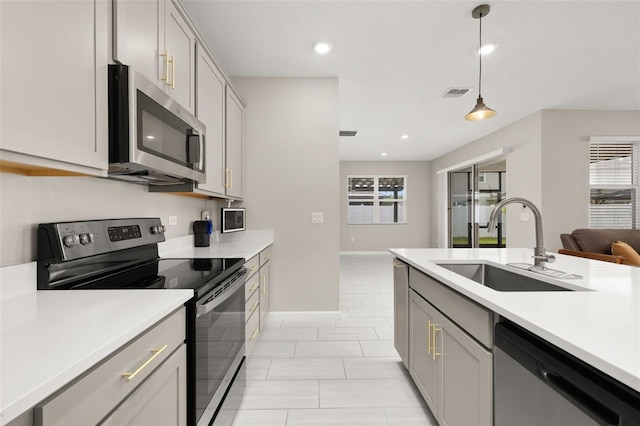 236 Pink Ibis Bnd, Saint Cloud, FL 34772 - kitchen with stainless steel appliances, a sink, plenty of natural light, light countertops, and decorative light fixtures