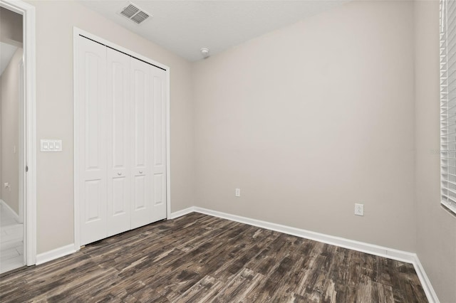 236 Pink Ibis Bnd, Saint Cloud, FL 34772 - unfurnished bedroom with baseboards, dark wood-style flooring, visible vents, and a closet