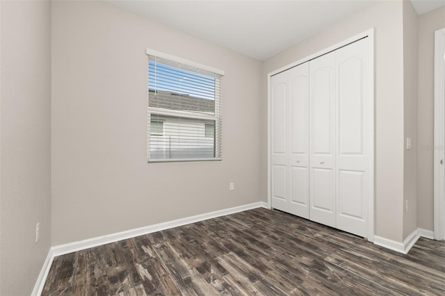 236 Pink Ibis Bnd, Saint Cloud, FL 34772 - unfurnished bedroom featuring dark wood-type flooring, a closet, and baseboards