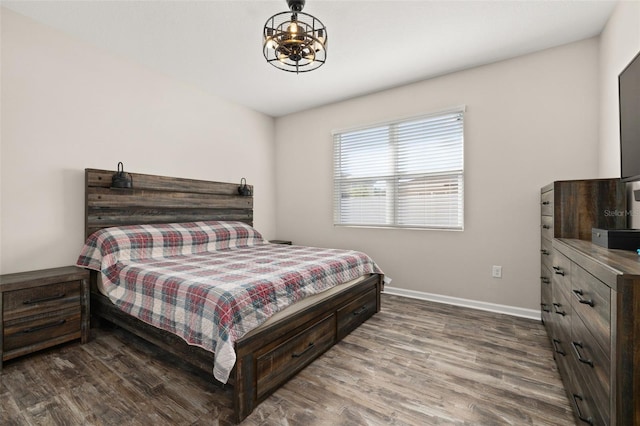 236 Pink Ibis Bnd, Saint Cloud, FL 34772 - bedroom with wood finished floors, baseboards, and a notable chandelier