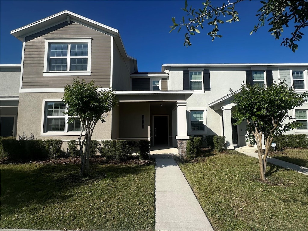 traditional-style home featuring a front lawn and stucco siding