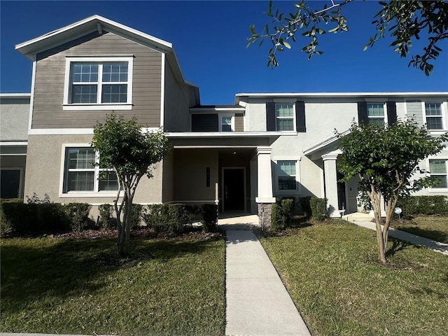 traditional-style home featuring a front lawn and stucco siding