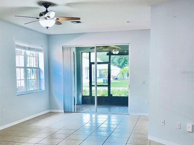 unfurnished room featuring light tile patterned floors, ceiling fan, and baseboards