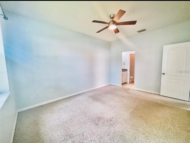 unfurnished bedroom featuring baseboards, visible vents, ensuite bath, and light colored carpet