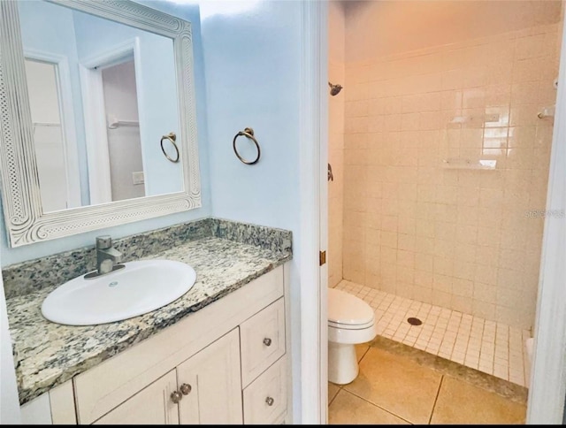 bathroom featuring toilet, a stall shower, tile patterned floors, and vanity