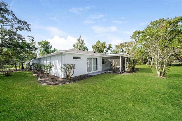 10237 Bannock St, Spring Hill, FL 34608 - back of property with stucco siding, a sunroom, and a yard
